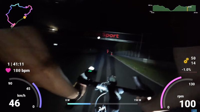 A bicycle rider passes the famous gantry at the Nurburgring during a nighttime race